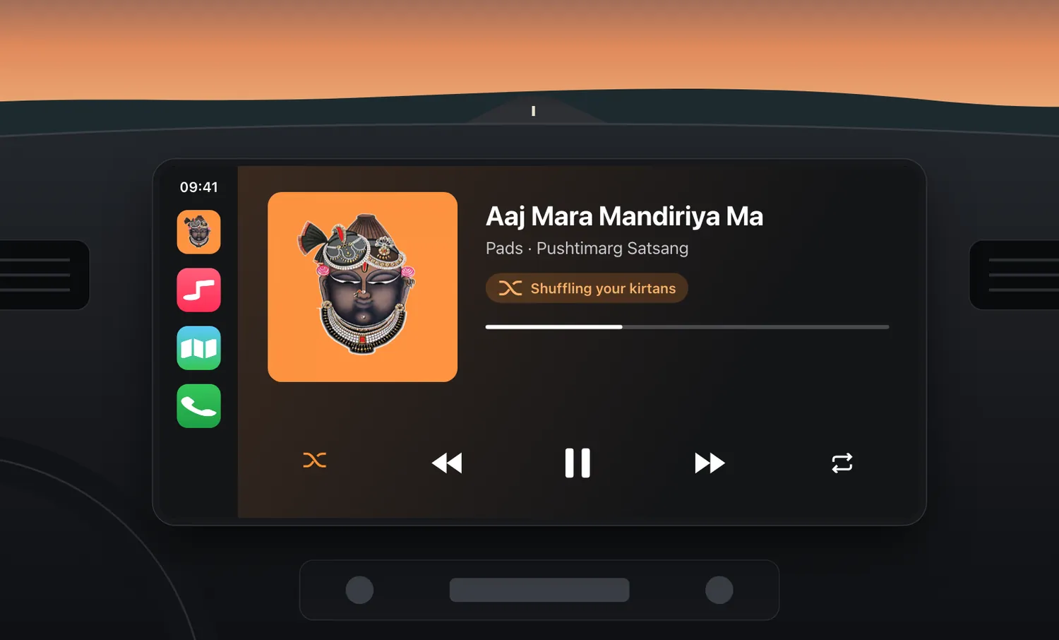 A car dashboard with Apple CarPlay showing a kirtan playing on shuffle.